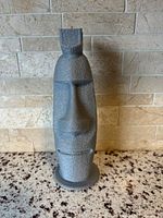 Front view of silver-gray 3D printed Moai sculpture on countertop