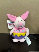 Front view of Piglet plush showing tags and costume