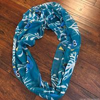 Full infinity scarf arranged in loop shape on wood floor