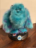 Front view of Sulley plush on base showing overall appearance and control button