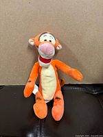 Full view of Tigger plush seated, showing overall appearance