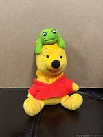 Front view of Pooh plush with frog accessory