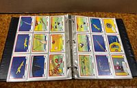 Open binder showing two plastic pages filled with Looney Tunes All-Stars cards
