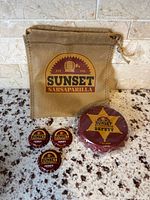 Full set: burlap bag, three bottle caps, deputy magnet (front)