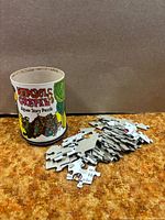 Tin with Hansel & Gretel label and loose puzzle pieces