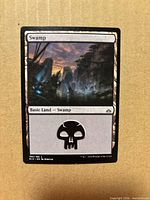 Front of Swamp card showing artwork, set code RIX 196/196, skull mana symbol