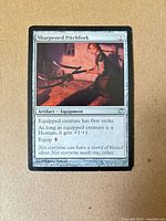Front of Sharpened Pitchfork card showing artwork, text box and wear