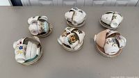 Six stacks of assorted floral porcelain teacups nested on matching saucers