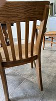 Rear view of side chair showing vertical slat back and oak grain
