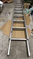 Aluminum extension ladder segment lying on floor