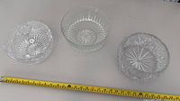 Three clear cut glass bowls measured with tape