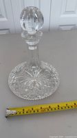 Full decanter with stopper, tape measure showing base diameter