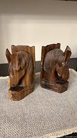Front three-quarter view of both wooden horse head bookends