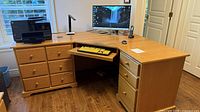 Front view showing desk shape, drawer arrangement, keyboard tray, surface
