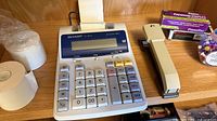 Calculator, stapler, staple box, paper rolls, push pin container