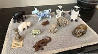 Group shot of all 12 animal figurines on mat