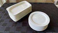Stacked oblong platters beside stacked round plates