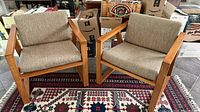 Both armchairs with cushions on rug