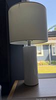 Full view of one lamp on table showing shade and base
