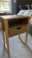 Front view of one nightstand showing shelf and drawer