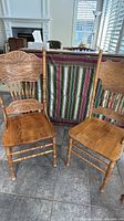 Front view of both oak dining chairs showing carved backs, seats and legs