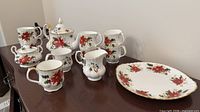Full set on tabletop showing teapot, sugar bowl, creamer, mugs, serving platter