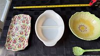 Top view of platter, Pyrex divided dish, flower bowl and fork with measuring tape for scale