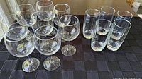 Group of 8 wine glasses and 5 highball glasses on table