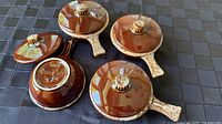Top view of all four bowls with lids showing glaze and markings on one base