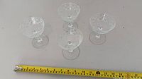 Set of four crystal champagne coupes with tape measure for scale