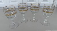 All four matching wine glasses showing design and wear