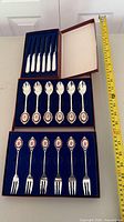 All three presentation boxes opened showing knives, forks and spoons