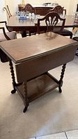Front view of oak drop-leaf tea cart with leaves down