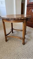 Full view of round oak end table showing overall form and finish wear