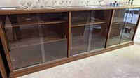 Front view showing entire length, glass doors, shelves