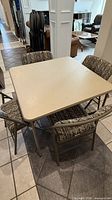 Square folding table with four chairs arranged around it