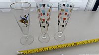 Overview of the three champagne flutes with tape measure showing length