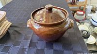 Brown glazed stoneware bean pot with lid, showing exterior