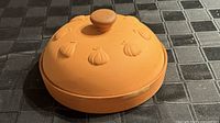 Lid on baker showing embossed garlic motif and knob handle