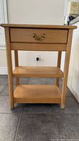 Front view showing full end table structure, drawer, shelves