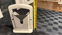 Full view of assembled bagel slicer next to tape measure showing height