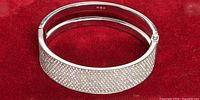 Full view of bracelet on red background showing pavé crystal front and clasp