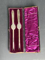 Two sterling silver lobster forks in open velvet-lined case