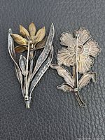 Back view of both sterling brooches showing pin mechanisms and hallmark area