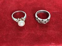 Front view of both sterling silver rings showing pearl and link designs