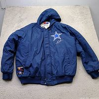 Front view of full coat showing logo, patch, hood, cuffs, waistband