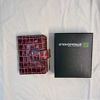 Wallet front view beside branded box