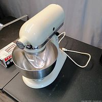 Mixer left side view with bowl, beater, power cord and boxed accessory
