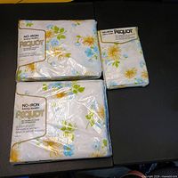 Three sealed Pequot bedding packages: fitted sheet, flat sheet, pillowcases