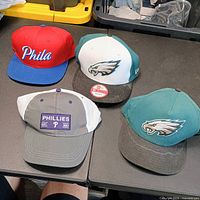 All four Philadelphia team hats on table